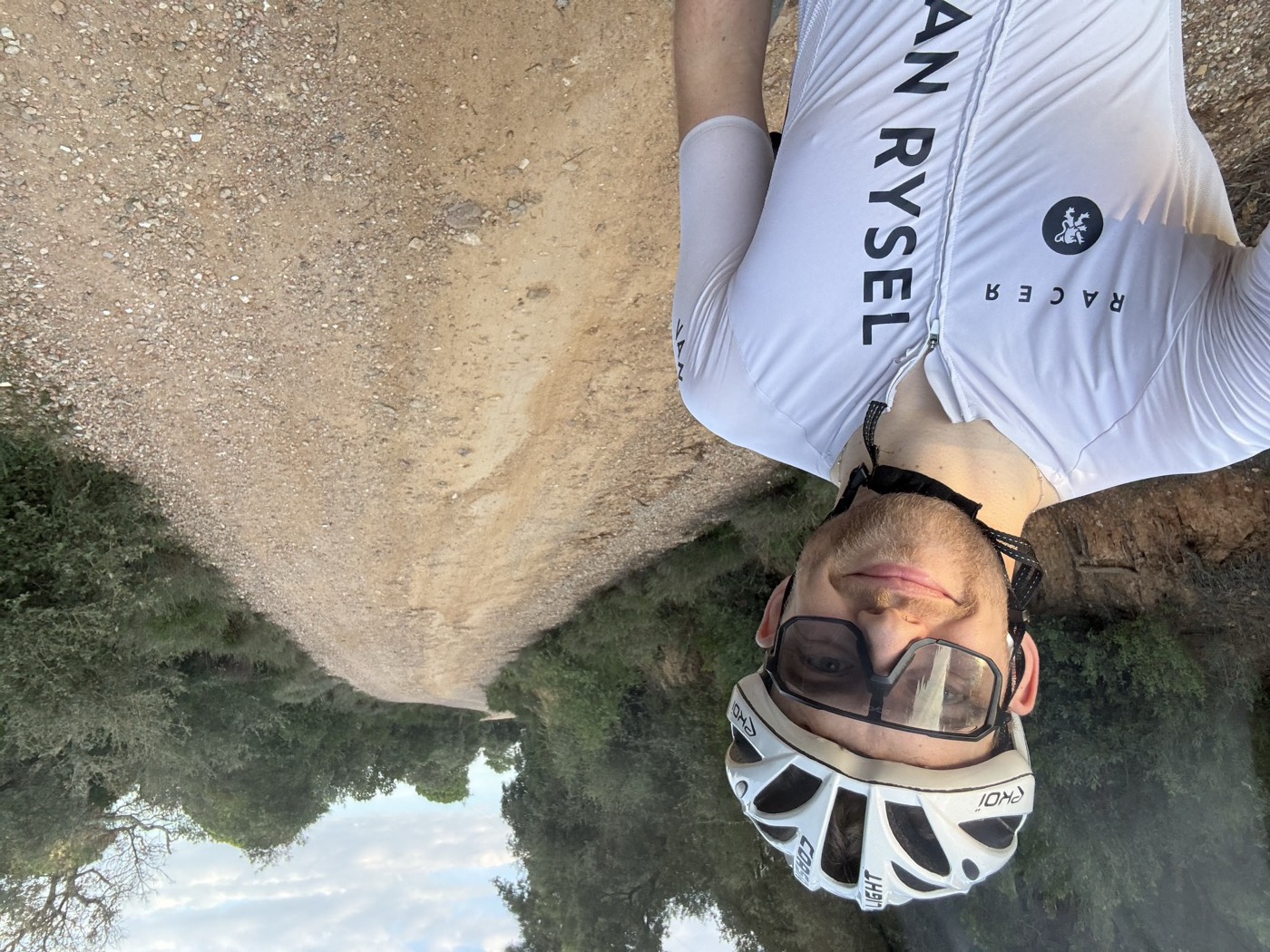 Tony O'Halloran in a cycling helmet on a gravel road, grinning
